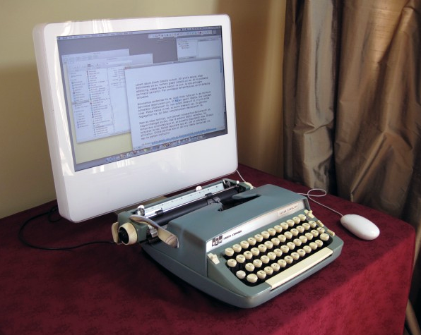 a typewriter hooked up to a computer screen